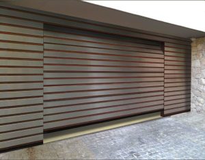 Großes modernes Garagentor mit horizontalen Paneelen in Holzoptik, eingefasst von Steinmauer und überdachtem Bereich