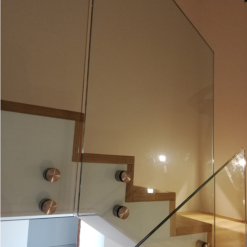 Innenansicht einer Holztreppe mit elegantem Glasgeländer und Edelstahlbefestigungen