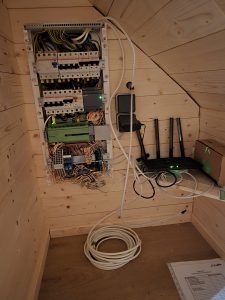 Detailaufnahme eines geöffneten Smart Home Verteilers mit Loxone Miniserver, Sicherungsautomaten und umfangreicher Verkabelung – professionelle Installation durch FuMa OG für intelligente Haussteuerung