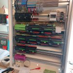 Offener Verteilerkasten mit Loxone Miniserver, Extensions, Reihenklemmen und Werkzeug auf der Werkbank – Elektroinstallation in Arbeit