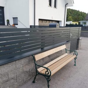 Anthrazitfarbener Aluminiumzaun mit waagerechter Lamellenstruktur vor einem Einfamilienhaus – langlebiger Sichtschutz mit moderner Optik, geeignet für automatisierte Zugangslösungen von FuMa OG