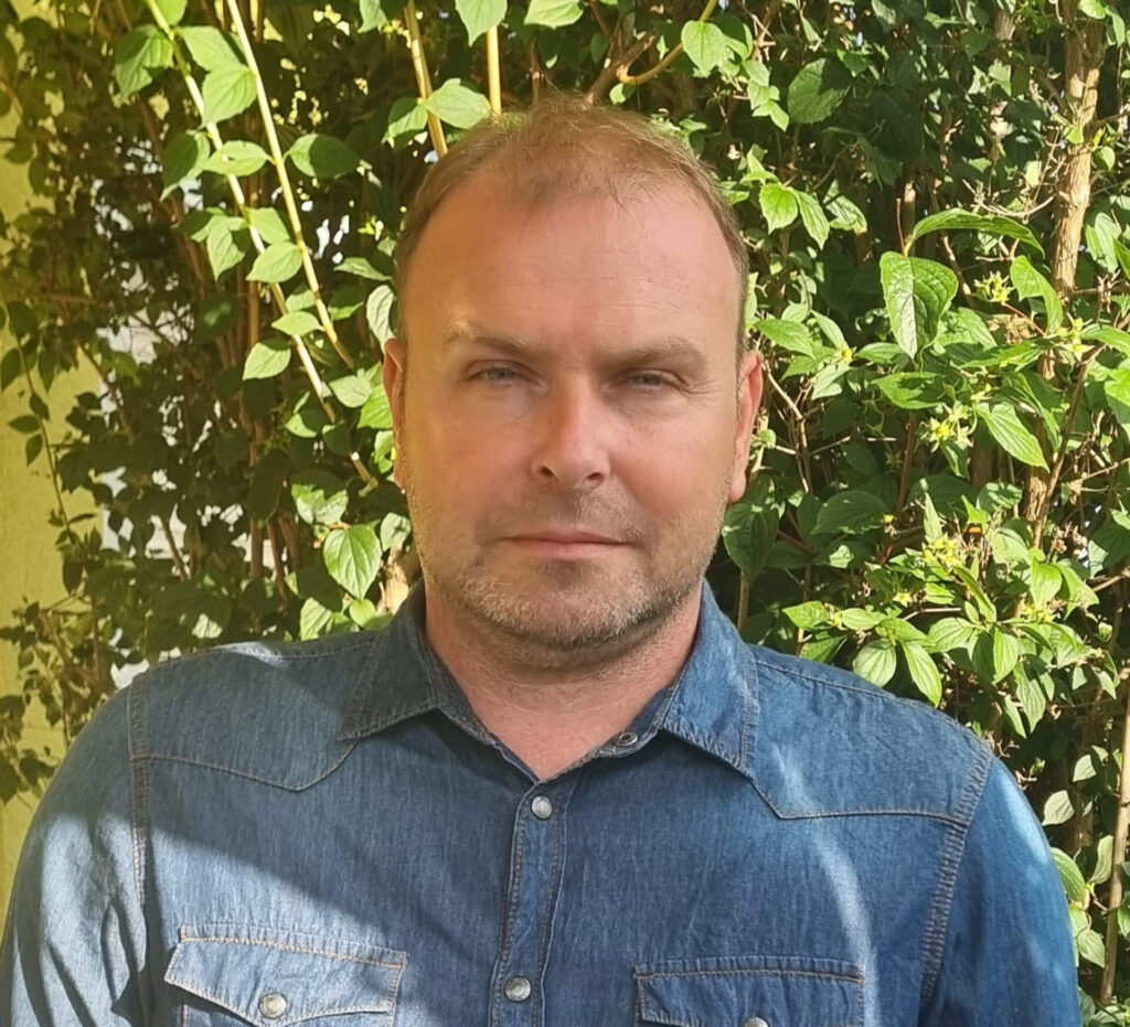 Portrait von Maurer Michael, Geschäftsführer der FuMa OG, vor einer begrünten Gartenanlage